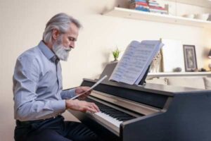 Adult male learning to play piano on a digital piano